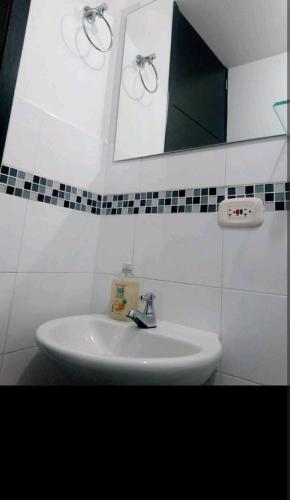 a white sink in a bathroom with a mirror at Alojamiento "Cómo en CASA" cerca al Aeropuerto!! in Bogotá