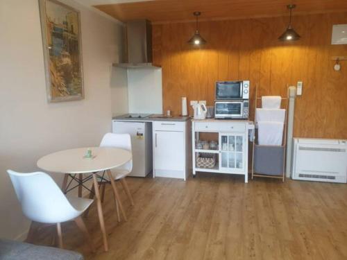 een keuken met een tafel en een tafel en stoelen bij New, Cosy & Private 1-Bedroom & Living Flat in Porirua