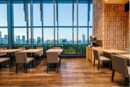 a restaurant with tables and chairs and a view of the city at THE BLOSSOM HIBIYA in Tokyo