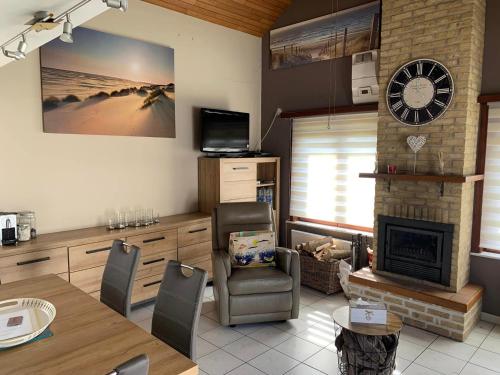 een woonkamer met een open haard en een klok aan de muur bij Aux 3 P'tits Wallons in Middelkerke