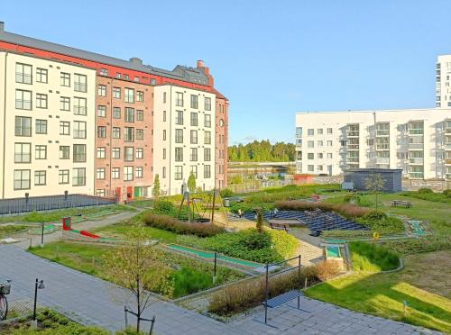 a park in the middle of a city with buildings at Toppilansalmi two bedroom apartment with a view in Oulu