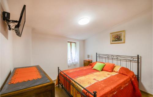 1 dormitorio con 1 cama con manta naranja en 1 Bedroom Nice Home In Equi Terme, en Equi Terme