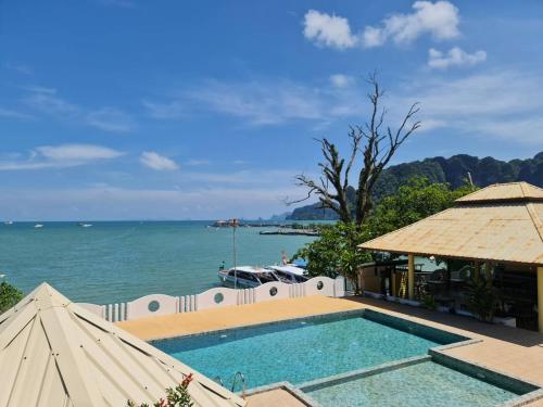 a swimming pool with the ocean in the background at Chom By The Sea in Ao Nam Mao