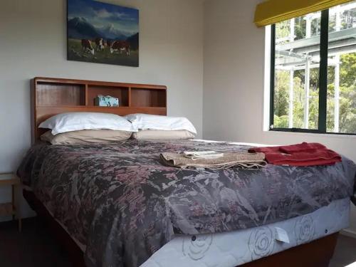 a large bed in a bedroom with a window at Peaceful and close to town in Whangarei