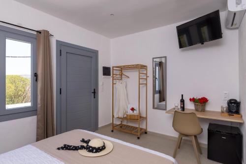 a bedroom with a bed and a desk and a mirror at Chrysonisos Suites with Sunset & Seaviews near Kini in Ano Syros