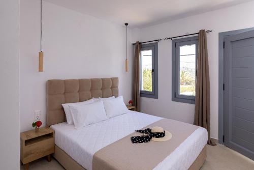 a bedroom with a large white bed with two hats on it at Chrysonisos Suites with Sunset & Seaviews near Kini in Ano Syros