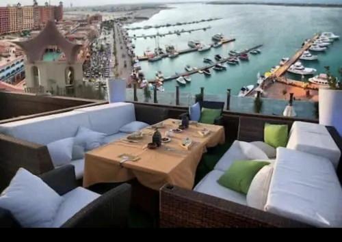 a restaurant with a view of a harbor with boats at private chalets in porto marina in El Alamein