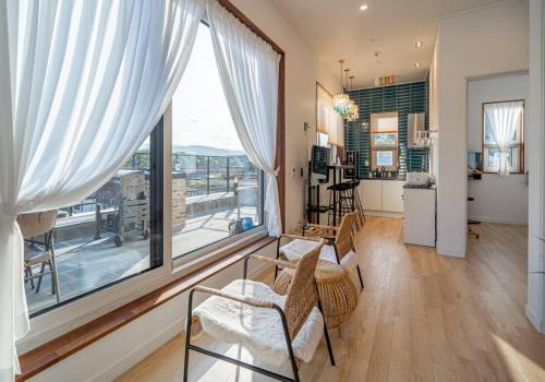 a living room with a large window and a kitchen at Dignitas Luxury Villa in Gangneung