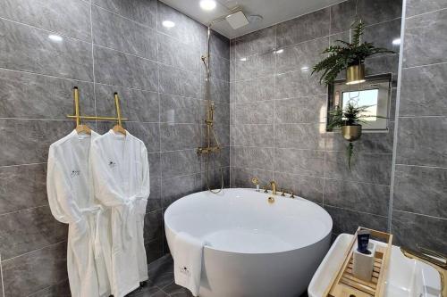 a bathroom with a large tub and a sink at Dignitas Luxury Villa in Gangneung
