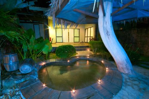 a small pool with lights in a backyard at night at Felda Residence Hot Springs in Sungkai