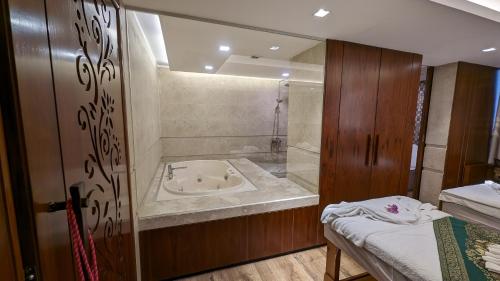 a bathroom with a bath tub and a sink at The Peninsula Chittagong Limited in Chittagong