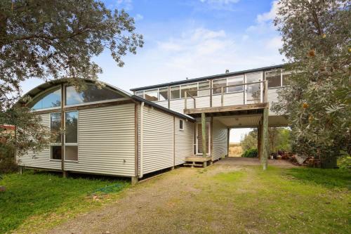 a large white house with a large window and a garage at Modern Sanctuary by the Silverleaves Beach in Rhyll