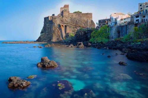 a view of a body of water with a castle at Blu Mediterraneo - Seaview luxury house in Acitrezza