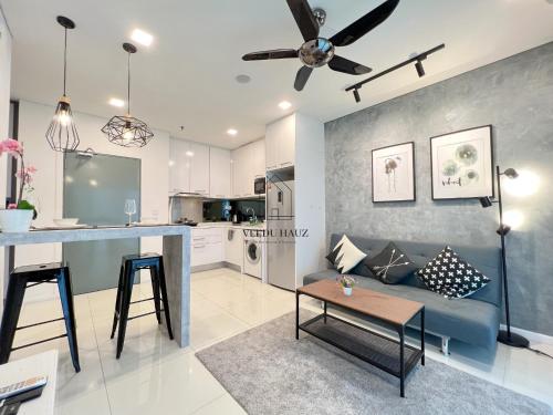 a living room with a blue couch and a kitchen at Mercu Summer Suites KLCC by Veedu Hauz in Kuala Lumpur