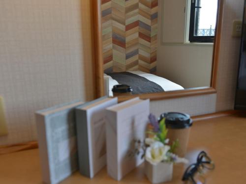 two monitors on a desk in front of a mirror at Hotel New Gaea Itoshima in Itoshima