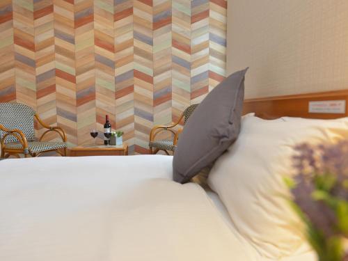 a bedroom with a bed with a pillow on it at Hotel New Gaea Itoshima in Itoshima