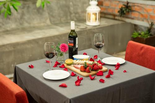 a table with a bottle of wine and wine glasses at Cambana d'Angkor Suites in Siem Reap