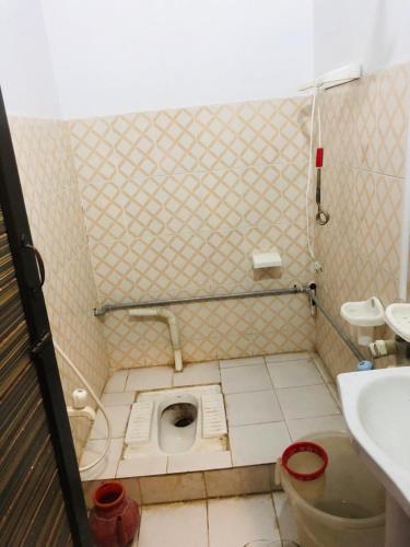 a dirty bathroom with a toilet and a sink at Zara Residence 1 in Swat