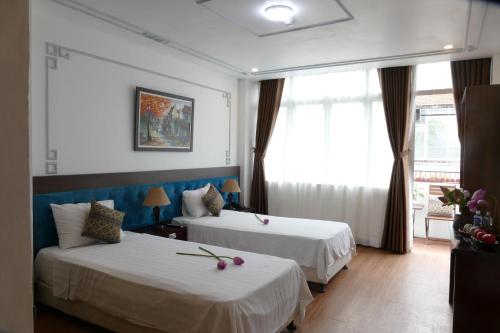 Habitación de hotel con 2 camas y ventana en MH Hanoi Hotel, en Hanói