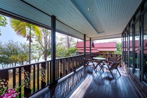a balcony with a table and chairs on it at Phi Phi Natural Resort in Phi Phi Don