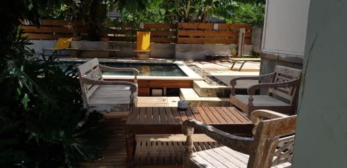patio z 2 krzesłami i stołem oraz basenem w obiekcie le raphael ( chambre piscine) w mieście Saint-Joseph
