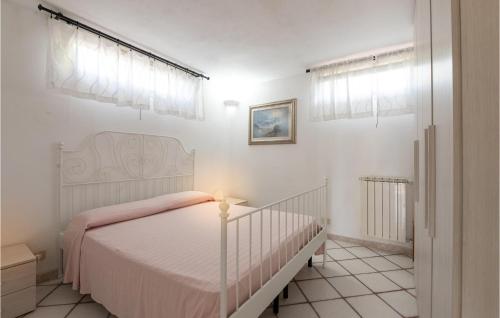 um quarto branco com uma cama com um cobertor rosa em Lovely Home In Porto S,stefano With Wifi em Santa Liberata
