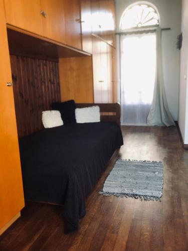 a bedroom with a bed and a large window at Planitis Lighthouse View in Pánormos