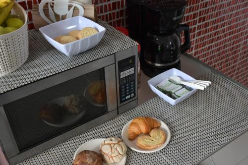 a counter with a microwave with a plate of bread at Villa Leo in Cancún