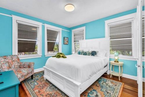 a blue bedroom with a white bed and a chair at Resort-style Estate w/ Pvt Guest Suites- Sleeps 15 in West Palm Beach