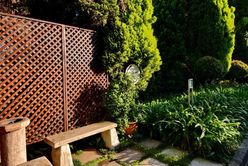 a wooden bench sitting next to a bush at Road Lodge JNB Airport in Johannesburg