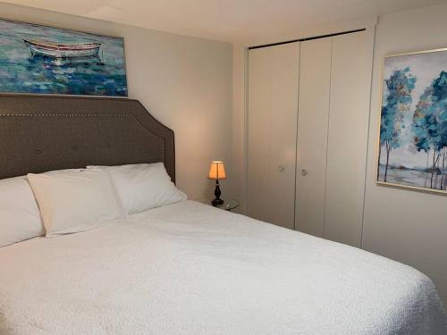 Un dormitorio con una cama blanca y una pintura en Cosy country mobile home on 18 acres farm sleeps 5, en Port Alberni