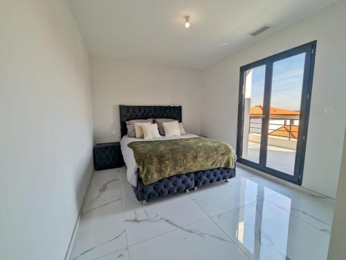 Un dormitorio con una cama y una ventana grande. en Le Petit Dubaï, en Saint-Jean-Lasseille