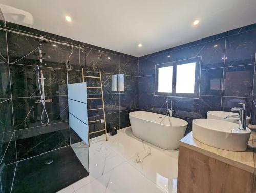 Un baño con bañera, lavabo y ducha. en Le Petit Dubaï, en Saint-Jean-Lasseille