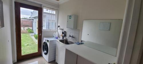 uma cozinha com um lavatório e uma máquina de lavar roupa em Entire 3 bed rooms unit -Rosy house 1 em Noble Park