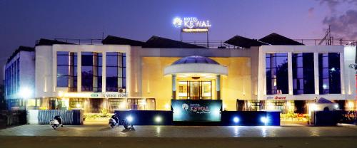 a building with two people on motorcycles in front of it at Hotel Kewal in Nashik
