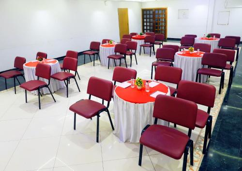 a room with red and white tables and chairs at Hotel Kewal in Nashik