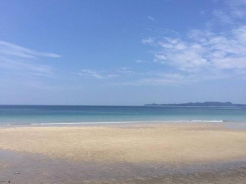 a sandy beach with the ocean in the background at BEACH HOUSE OHAMA in Kuranomoto
