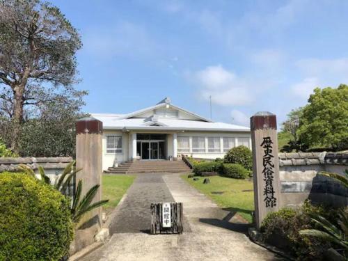 a white house with a gate in front of it at BEACH HOUSE OHAMA in Kuranomoto
