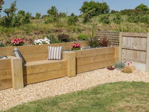 a wooden bench in the middle of a garden at 14 Parc Delfryn in Brynteg