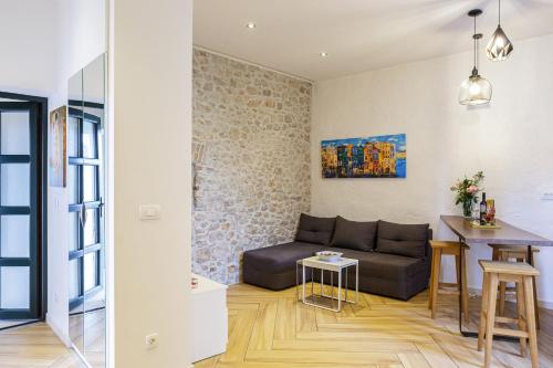 ein Wohnzimmer mit einem Sofa und einem Tisch in der Unterkunft PORT - unique apartment in Dubrovnik