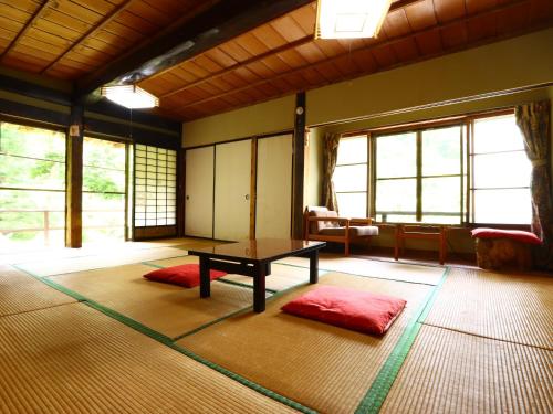 ein Zimmer mit einem Tisch in der Mitte eines Zimmers in der Unterkunft Minshuku Sawaguchi in Agematsu