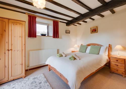 a bedroom with a large white bed and red curtains at Coach House in Llanfachreth