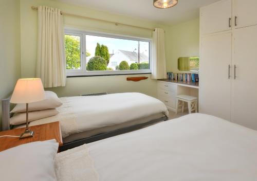 a bedroom with two beds and a window at Mor Gragen in Abersoch