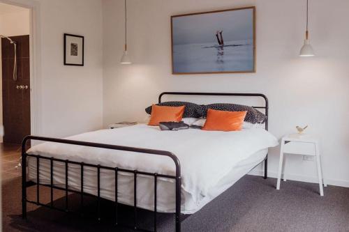 een slaapkamer met een bed met oranje en zwarte kussens bij Lifebuoy Beach House Bicheno in Bicheno