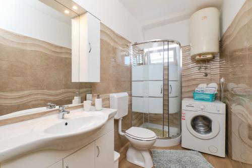 La salle de bains est pourvue d'un lavabo et d'un lave-linge. dans l'établissement Sea View Apartment Sandra in Mali Lošinj, à Mali Lošinj