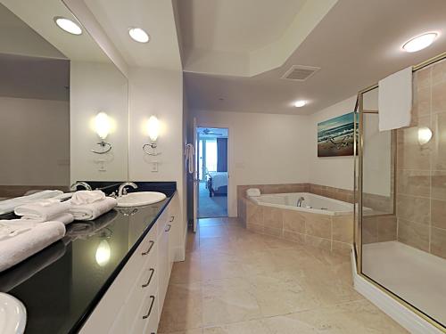 een badkamer met 2 wastafels, een douche en een bad bij Caribe The Resort #C504 in Orange Beach