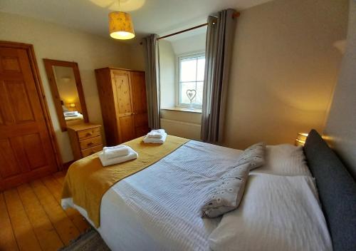 a bedroom with a bed with two towels on it at Llwyniarth in Dolgellau