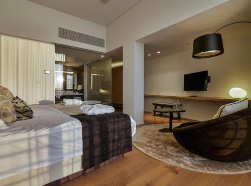 a hotel room with a bed and a chair at Cramim by Isrotel Exclusive in Qiryat ‘Anavim