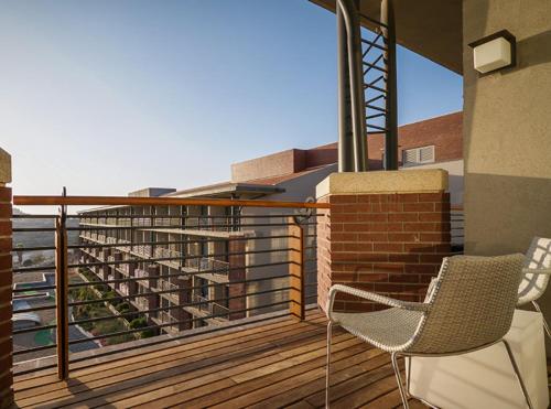 a balcony with two chairs and a view of a building at Cramim by Isrotel Exclusive in Qiryat ‘Anavim