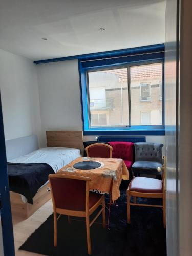 una stanza con un letto, un tavolo e delle sedie di une détente à la plage a Dunkerque